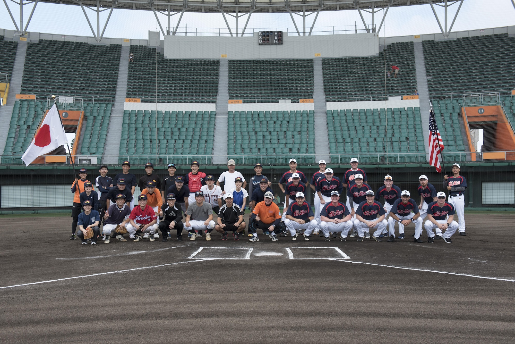 The Japan Air Self-Defense Force Southwestern Composite Air Division members and the Allstars pose for a group photo Oct. 15, 2016, at the Cellular Stadium in Naha, Japan. U.S. consul, Naha and military members stationed on Okinawa make up team Allstars. (U.S. Air Force photo by Senior Airman Omari Bernard)