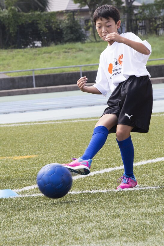 A local Japanese child kicks a ball during a soccer drill at the U.S.-Japan Children Soccer event at the Suo-Oshima Athletic Field in Suo-Oshima, Japan, Oct. 1, 2016. The soccer drill tested the children’s accuracy and ability to score at different lengths of the field. While cheering each other on, players aimed to kick the ball at 30 meters into a goal through cones simulating defenders. (U.S. Marine Corps photo by Lance Cpl. Joseph Abrego)