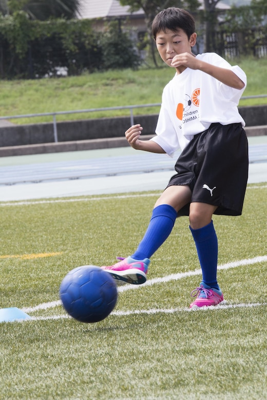A local Japanese child kicks a ball during a soccer drill at the U.S.-Japan Children Soccer event at the Suo-Oshima Athletic Field in Suo-Oshima, Japan, Oct. 1, 2016. The soccer drill tested the children’s accuracy and ability to score at different lengths of the field. While cheering each other on, players aimed to kick the ball at 30 meters into a goal through cones simulating defenders. (U.S. Marine Corps photo by Lance Cpl. Joseph Abrego)