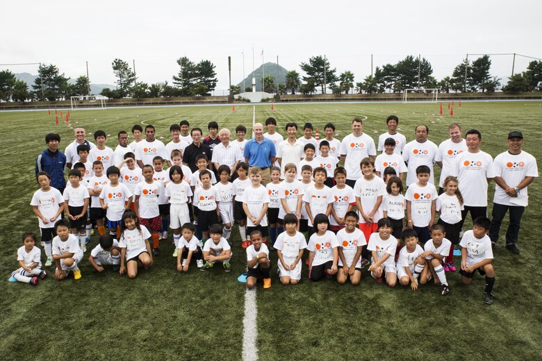 Marine Corps Air Station Iwakuni residents and Japanese locals pose for a group photo during the U.S.-Japan Children Soccer event at the Suo-Oshima Athletic Field in Suo-Oshima, Japan, Oct. 1, 2016. As part of a good keeping with the U.S.-Japan relationship, soccer was used to break the barrier of communication through words and teach children communication through actions. (U.S. Marine Corps photo by Lance Cpl. Joseph Abrego)