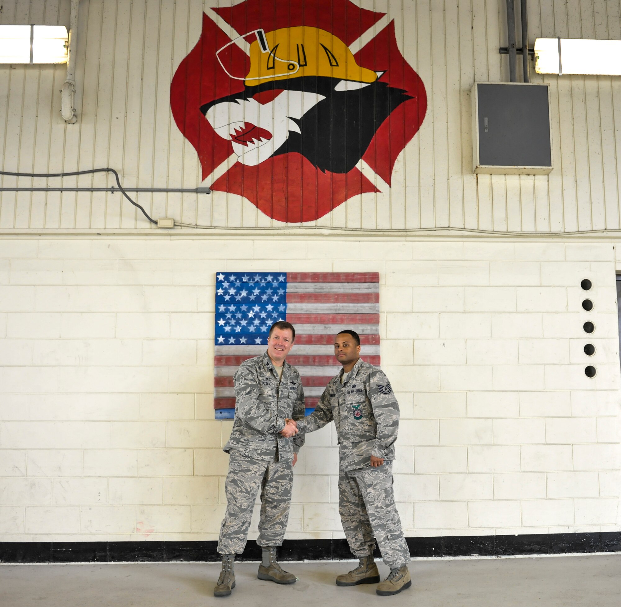 Tech. Sgt. Darnell Dobson, 8th Civil Engineer Squadron fire fighter, shakes hands with Col. Todd “Wolf” Dozier, 8th Fighter Wing commander, for his leadership role during a fire on Kunsan Air Base, Republic of Korea, Oct. 21, 2016. Through his communication and training as the incident commander, he was able to coordinate a plan of action to defeat the fire. Due to his efforts, Dobson and his team saved a 2.6 million dollar building. (U.S. Air Force photo by Senior Airman Colville McFee/Released)  
