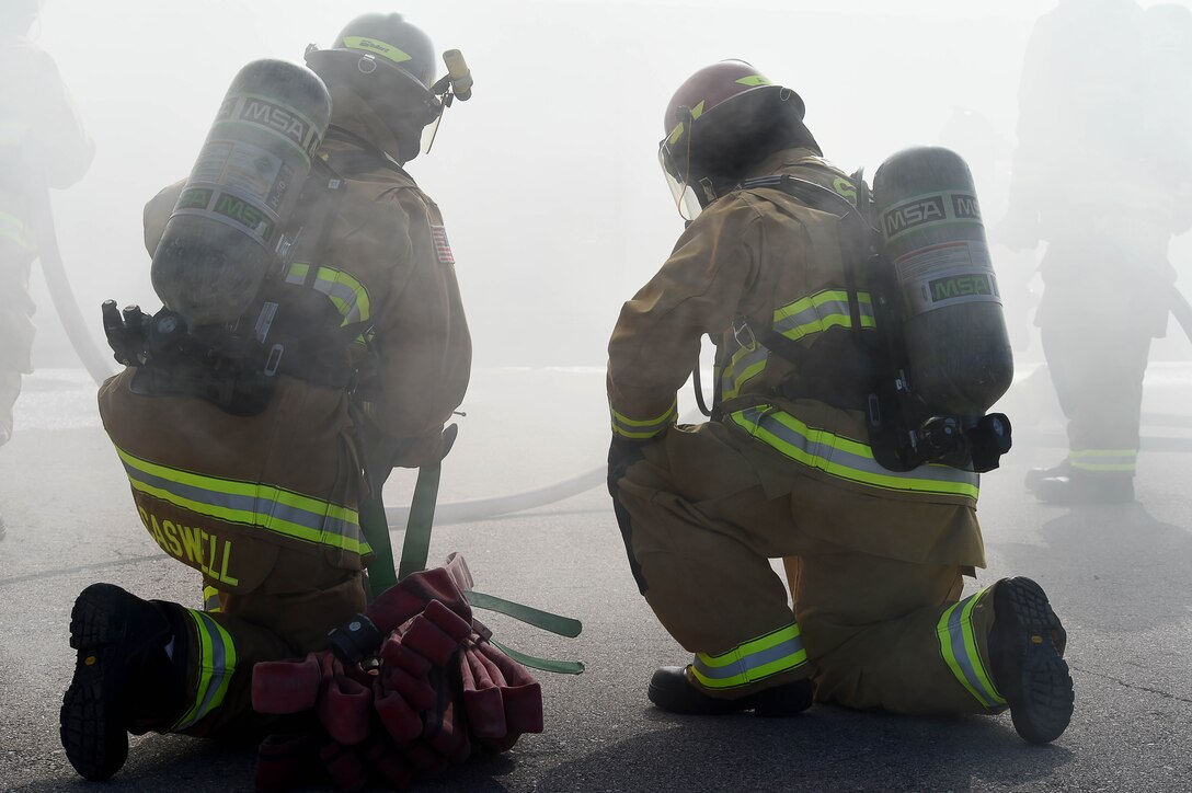 Firefighters assigned to the 99th Civil Engineer Squadron Fire Protection Flight, prepare to enter a live burn exercise Sept. 23, 2016, at Creech Air Force Base, Nev. The 99th CES Fire and Emergency Services hosted the exercise to showcase their capabilities to distinguished visitors. (U.S. Air Force photo by Airman 1st Class James Thompson) 