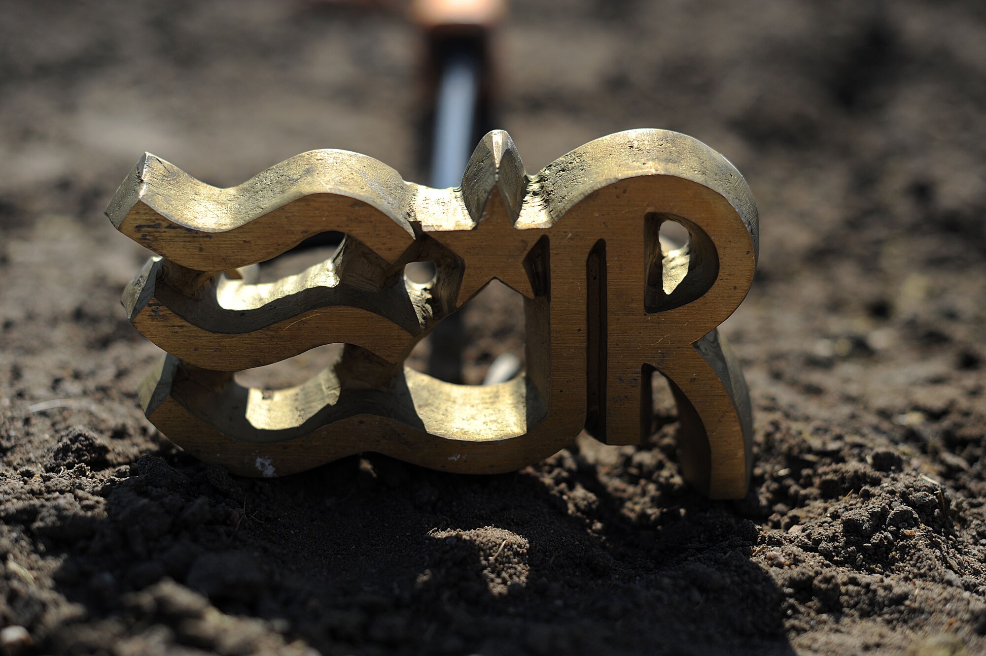 A horse brand sits in the dirt Oct. 13, 2016, in Wichita, Kan. The brand belongs to Airman 1st Class Lauren Nolan, 22nd Logistics Readiness Squadron materials management journeyman. The L stands for her first name, the R stands for her middle name, Rae, and the stars and stripes represents her time in service. (U.S. Air Force photo/ Airman 1st Class Jenna K. Caldwell)