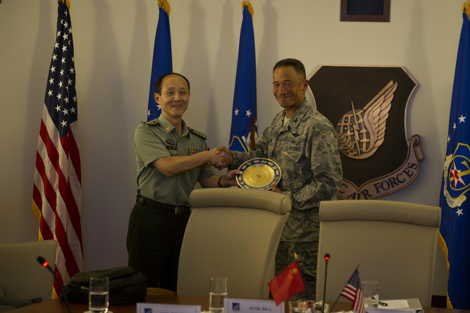 People's Liberation Army Senior Col. Hua Bo and U.S. Air Force Col. Art Primas, Pacific Air Forces International Affairs division chief, exchange gifts following a mid-level officer exchange at Joint Base Pearl Harbor-Hickam, Hawaii, Oct. 18, 2016. The PLA delegation visited PACAF as part of an annual exchange tour that included a stop at U.S. Pacific Command. (U.S. Air Force photo by Staff Sgt. Alexander Martinez)