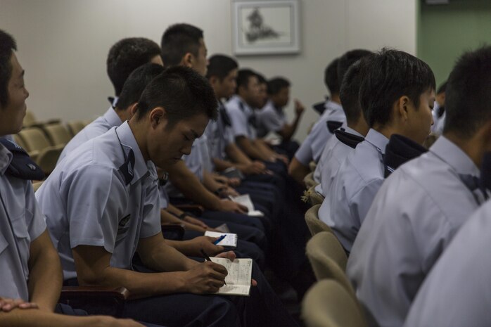 Japan Air Self-Defense Force aviation cadets with the 12th Flight Training Wing from JASDF Hōfu-kita Air Base takes notes during a Japanese officer engagement program at Marine Corps Air Station Iwakuni, Japan, Oct. 19, 2016. During the visit, approximately 40 cadets toured the air station to see an F/A-18D Hornet assigned to Marine All-Weather Fighter Attack Squadron (VMFA(AW)) 225 and a KC-130J Hercules belonging to Marine Aerial Refueler Transport Squadron (VMGR) 152. Cadets also took turns flying a KC-130J flight simulator and learned about Marine Aircraft Group 12 and the air station. (U.S. Marine Corps photo by Lance Cpl. Aaron Henson)