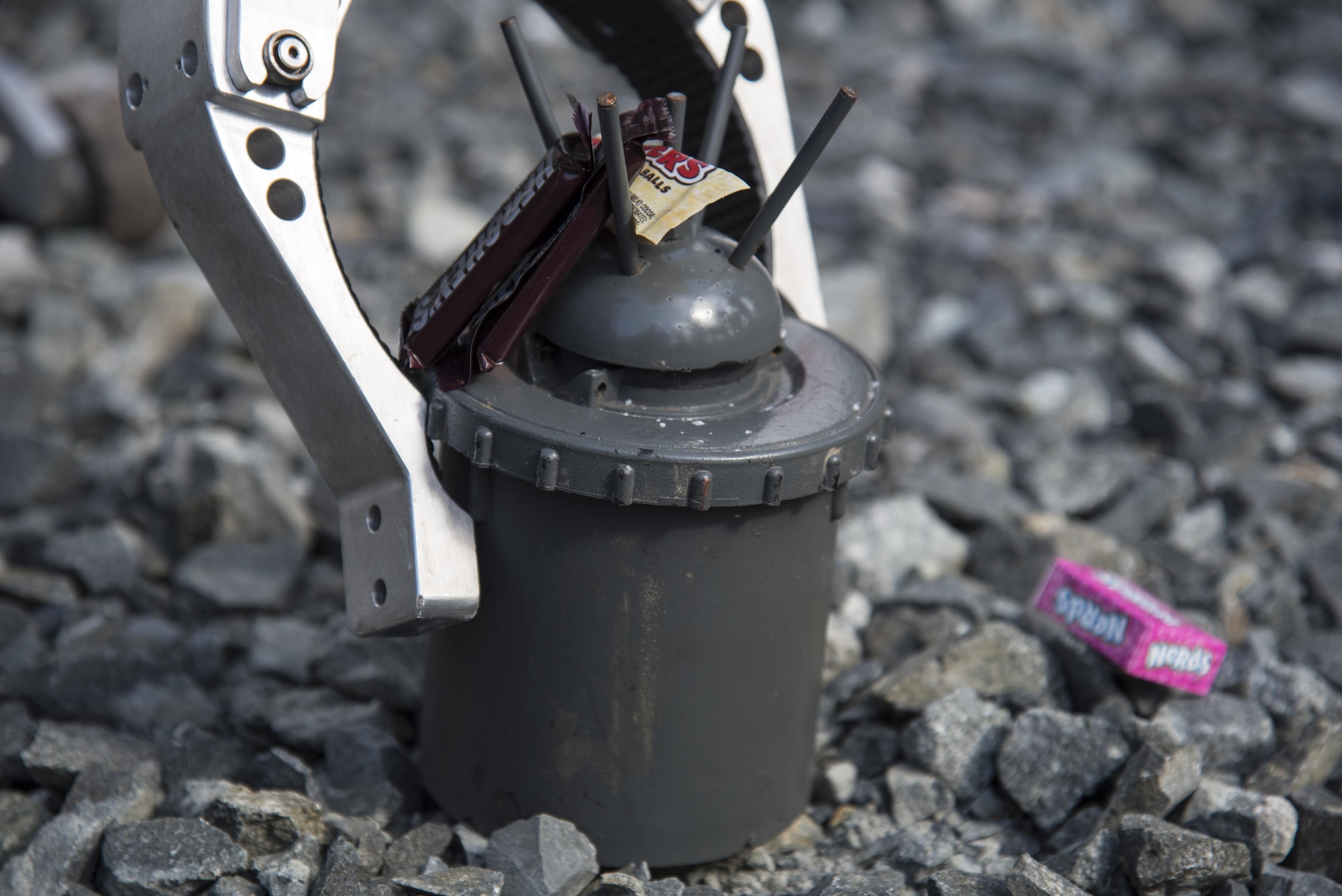 A landmine, also known as a 'bouncing betty,' sits with candy during a Range Day event at Misawa Air Base, Japan, Oct. 21, 2016. When set off by a trip wire, a first charge ignites at the bottom of the explosive causing it to bounce into the air, then a second charge causes the device to detonate. (U.S. Air Force photo by Airman 1st Class Sadie Colbert)
