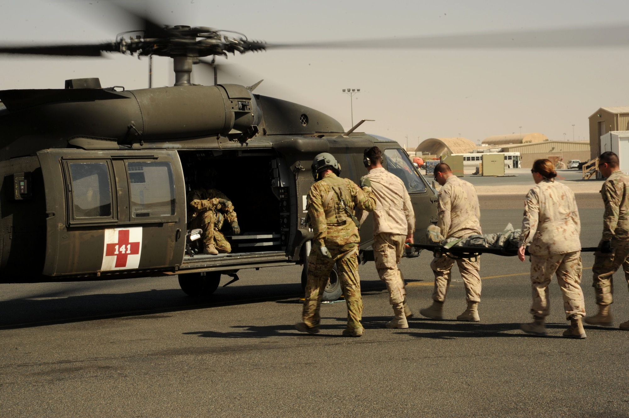 Medical personnel from team Canada and the 386th Expeditionary Medical Group perform a hot load during medical evacuation training Oct. 14, 2016 at an undisclosed location in Southwest Asia. The purpose of the training was to expand mission capabilities and enhance relationships between joint and coalition partners. (U.S. Air Force photo/Senior Airman Zachary Kee)