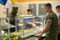 Chow hall employees and a Marine officer serves food to Marines and Sailors during the 241st Navy Birthday Meal held at Marine Corps Air Station New River, October 13, 2016. The meal included Grilled Steak, Baked Lobster Tails, Shrimp Cocktail and other side dishes. DOD employees, dependents of Marines, Military Retirees, Guests of Marines and Sailors and guests of the Commanding General were all eligible to attend. (U.S. Marine Corps photo by Cpl. Melodie Snarr/Released.)