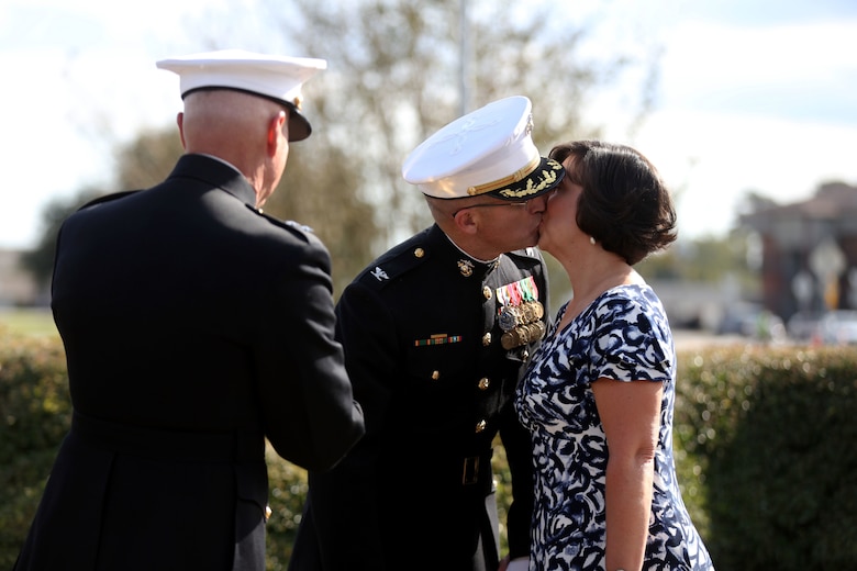 Col. Yori R. Escalante kisses his wife after she receives an award at his side, during his retirement ceremony at Marine Corps Base Camp Lejeune, Oct. 14. Col. Yori R. Escalante, deputy commander of Marine Corps Installation East - Marine Corps Base Camp Lejeune, retired today  after 30 years of faithful and dedicated service to the Marine Corps. (U.S. Marine Corps photo by Pfc. Juan Madrigal/Released)