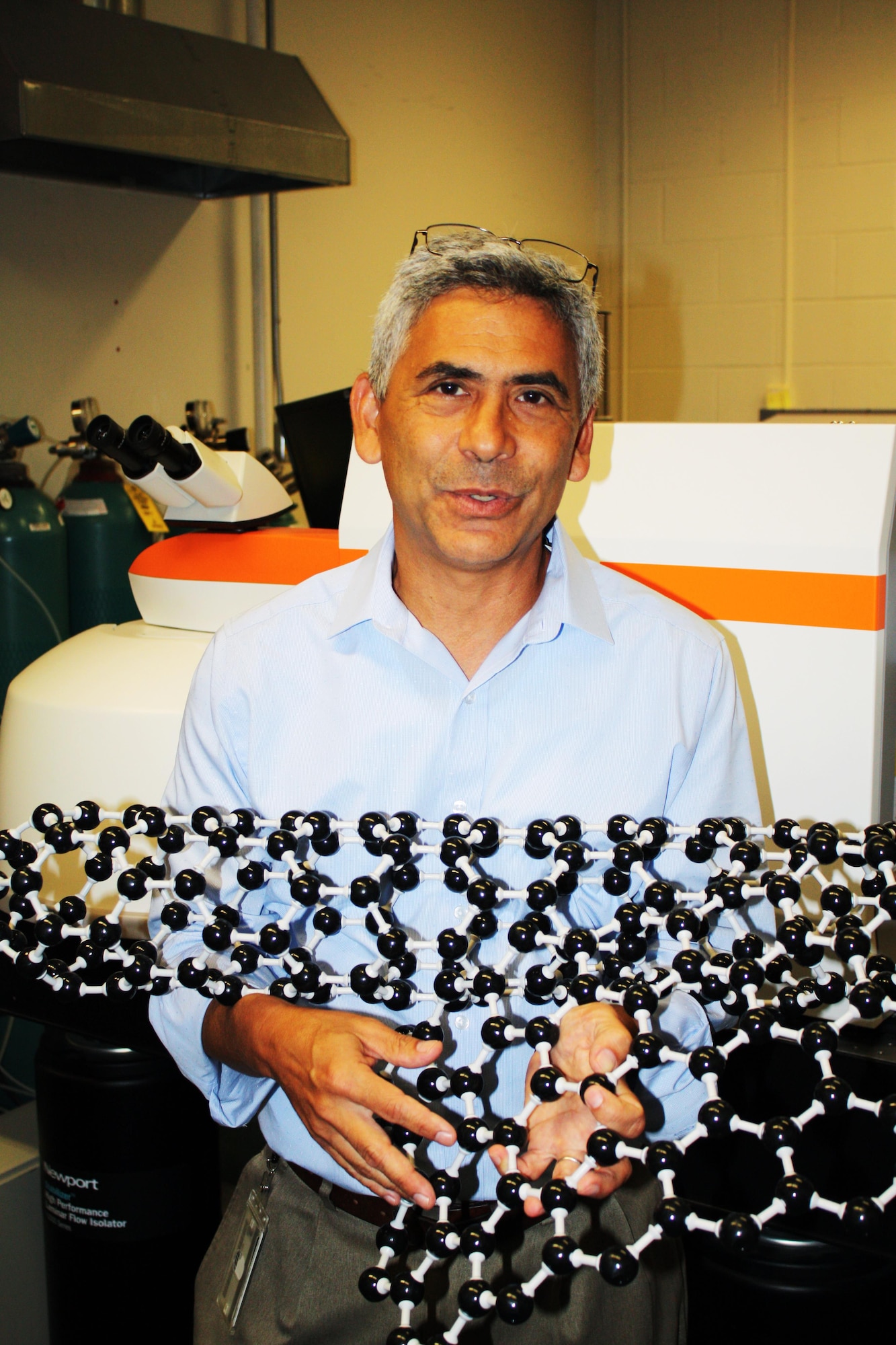 Dr. Benji Maruyama, a senior materials research engineer in the Functional Materials Division, Materials and Manufacturing Directorate, Air Force Research Laboratory, displays a model of a carbon nanotube structure. Carbon nanotubes are of great interest to materials scientists due to their strong, light-weight structure and ability to conduct heat and electricity better than many other materials. These nanotubes can be used in a number of different applications, from airplane wings to computer fiber, dental implants and even for oil spill clean-up. (U.S. Air Force photo/Marisa Novobilski). 
 
