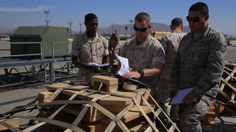 U.S. Marine Corps Lance Cpl. Bryson Leysath, Chief Warrant Officer 2 Robert Hallett and U.S. Air Force Tech. Sgt. Geoffrey Gaeraths inspect pallets containing M-88A2 HERCULES equipment at March Air Force Reserve Base, Calif., Oct. 14, 2016. Leysath, from Augusta, Ga., is an embarkation specialist with Combat Logistics Regiment 15, Hallett, from Mesa, Az., is a mobility officer with CLR 15 and Gaeraths, from Victorville, Calif., is a joint inspector with 452nd Logistics Readiness Squadron.