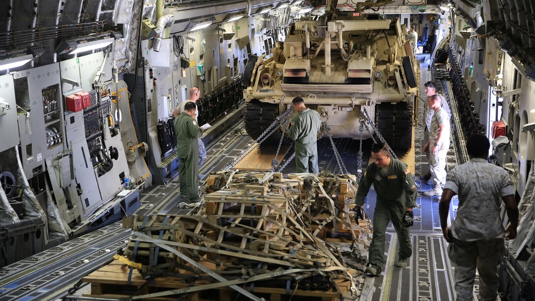 U.S. Marines and Airmen work together to properly secure the M-88A2 HERCULES and pallets in the C-17 Globemaster III at March Air Force Reserves Base, Calif., Oct. 14, 2016. Marines and Airmen checked all chains and pallets before flying to Marine Corps Air Ground Combat Center Twentynine Palms, Calif.
