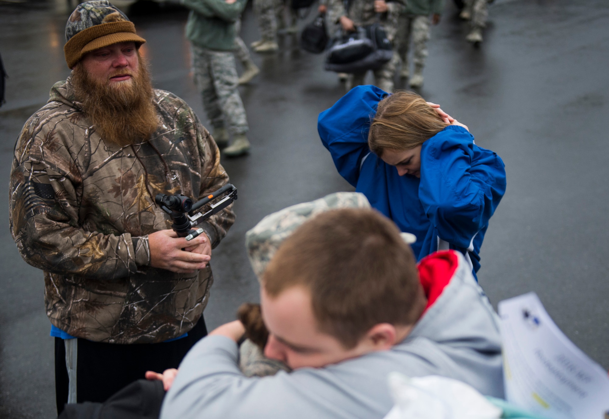A husband watches as his wife, an Airman assigned to the 606th Air Control Squadron, greets family during the squadron’s return to Spangdahlem Air Base, Germany, Oct. 20, 2016. The 606th ACS is a self-sustaining squadron consisting of maintenance, supply and approximately 21 other Air Force specialties. (U.S. Air Force photo by Airman 1st Class Preston Cherry)