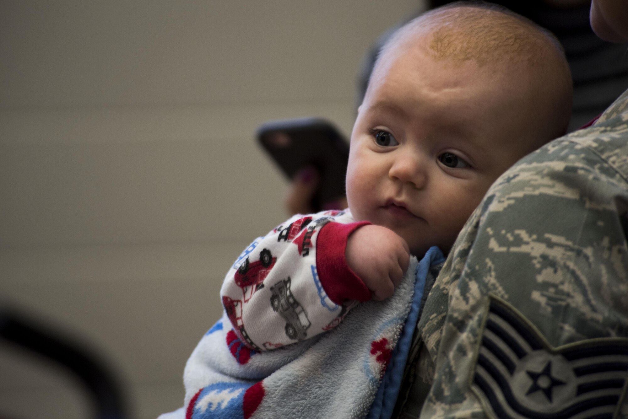 An infant child of two Airmen assigned to the 606th Air Control Squadron awaits his father's return from deployment, to their squadron at Spangdahlem Air Base, Germany, Oct. 20, 2016. Nearly 200 Airmen assigned to the 606th ACS returned, from a six-month rotational deployment to Southwest Asia in support of Operations Freedom’s Sentinel and Inherent Resolve. (U.S. Air Force photo by Staff Sgt. Joe W. McFadden)