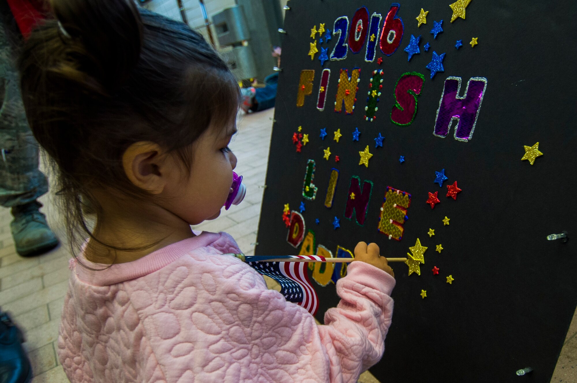 A child of an Airman assigned to the 606th Air Control Squadron awaits her father's return from deployment to their squadron at Spangdahlem Air Base, Germany, Oct. 20, 2016. Nearly 200 Airmen assigned to the 606th ACS returned, from a six-month rotational deployment to Southwest Asia in support of Operations Freedom’s Sentinel and Inherent Resolve. (U.S. Air Force photo by Staff Sgt. Joe W. McFadden)