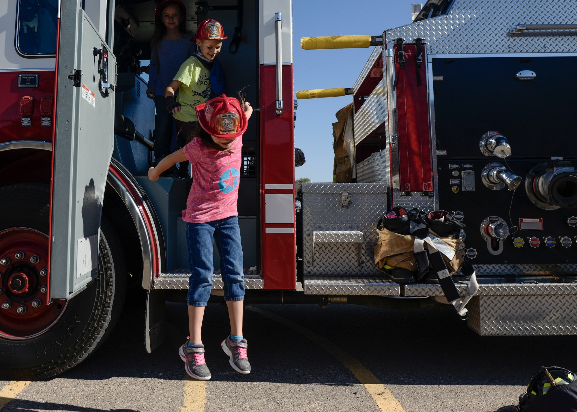 A child jumps from the back-end of a fire truck at Holloman Air Force Base’s elementary school as part of the base’s annual Fire Prevention Week, Oct. 11, 2016. Holloman AFB firefighters gifted each student an honorary plastic firefighter helmet and educated them on fire safety and prevention. (U.S. Air Force photo by Airman 1st Class Alexis P. Docherty)