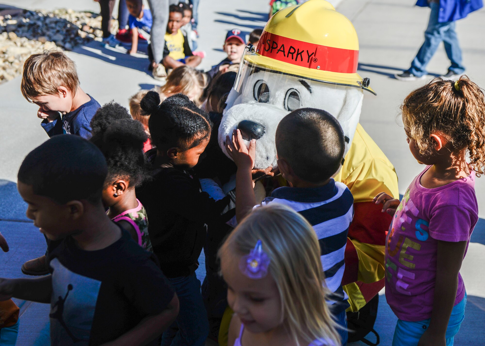 A group of children greet Sparky the Fire Dog during a visit to the child development center as part of Holloman Air Force Base’s annual Fire Prevention Week, Oct. 14, 2016. Members of the 49th Civil Engineer Squadron Fire Protection Flight also visited the center to teach children about fire safety and prevention. (U.S. Air Force photo by Airman 1st Class Airman Alexis P. Docherty)