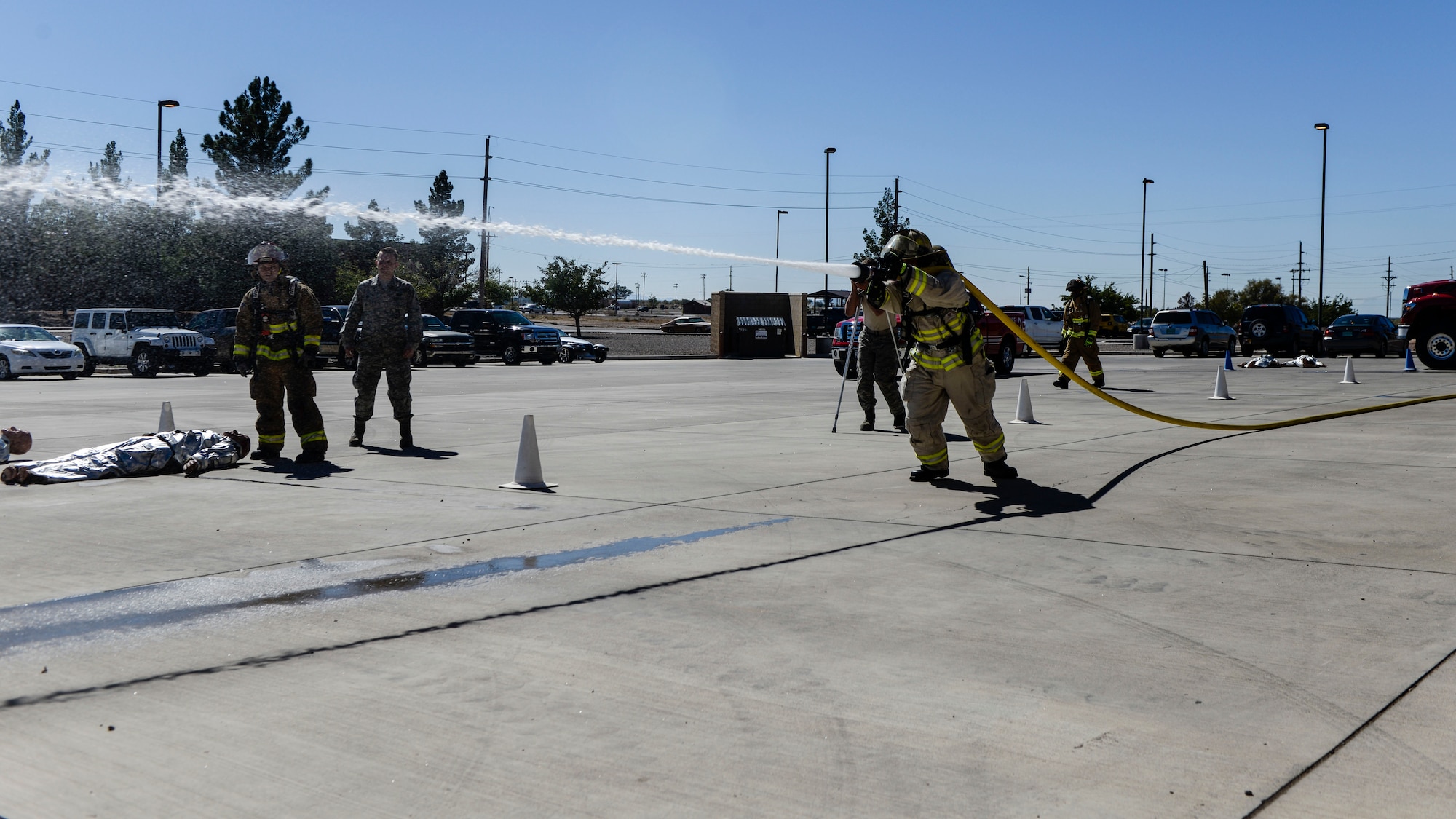 A competitor sprays a fire hose during the firefighter muster challenge, as part of Holloman Air Force Base’s annual Fire Prevention Week, Oct. 14, 2016 at Holloman AFB, N.M. Competitors were fitted in flame retardant suits and raced to complete a variety of physical tasks, including dummy drags and hose pulls. (U.S. Air Force photo by Airman 1st Class Alexis P. Docherty)