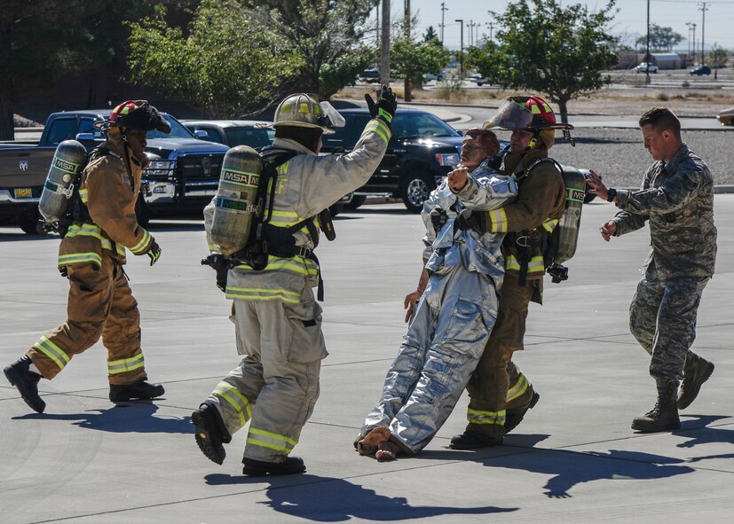 A competitor performs a body drag during the firefighter muster challenge, as part of Holloman Air Force Base’s annual Fire Prevention Week, Oct. 14, 2016 at Holloman AFB, N.M. Competitors were fitted in flame retardant suits and raced against the clock to complete a variety of intense physical tasks, which are meant to simulate the stressors that firefighters encounter on a daily basis. (U.S. Air Force photo by Airman 1st Class Alexis P. Docherty) 