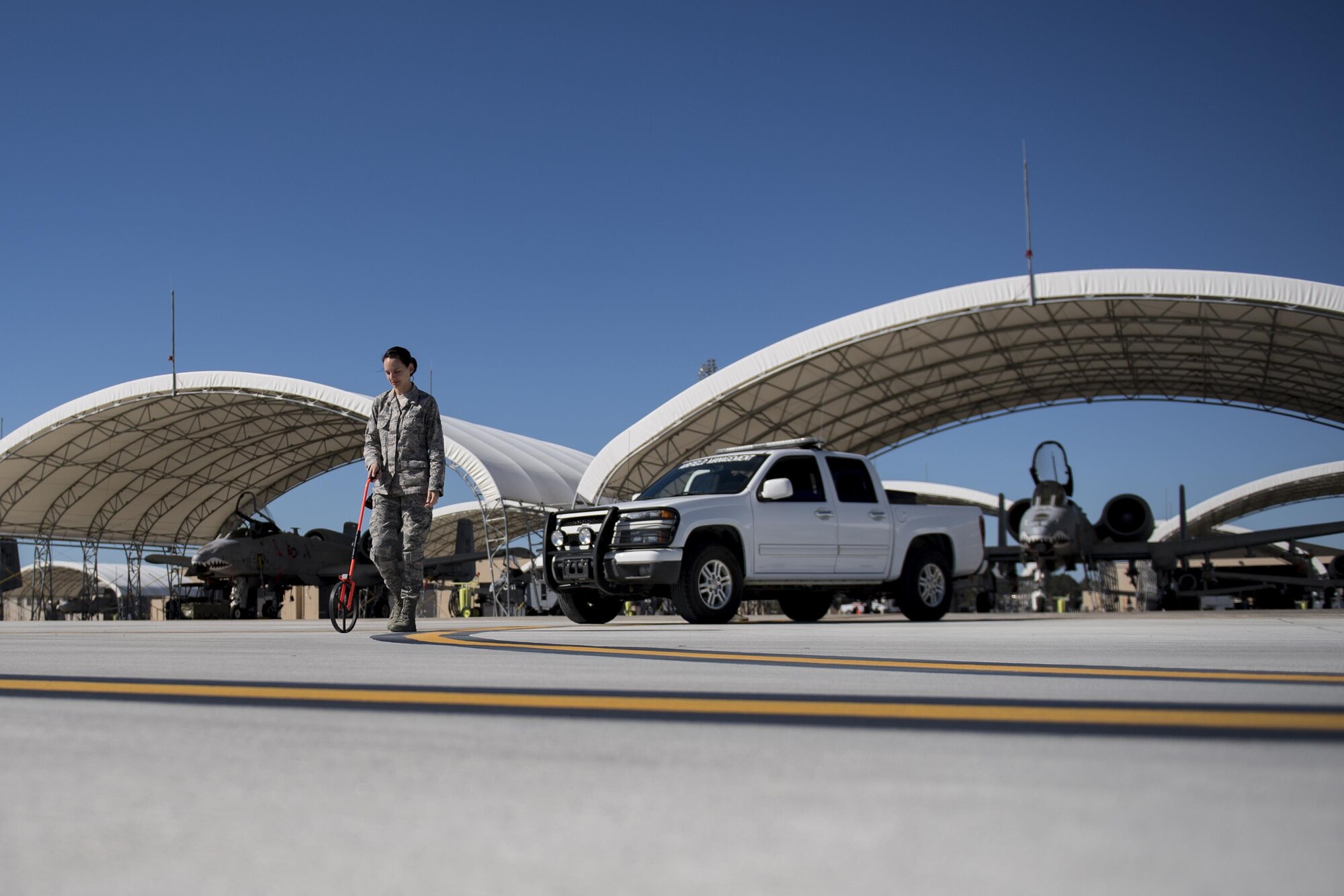 Senior Airman Kelsey Seroogy, 23d OSS airfield management shift leader, measures the distance between two painted lines on the flightline, Oct. 19, 2016 at Moody Air Force Base, Ga. Flightline markings are strategically and precisely placed to keep adequate spacing and ensure the safety of Airmen and aircraft. (U.S. Air Force photo by Airman 1st Class Daniel Snider)