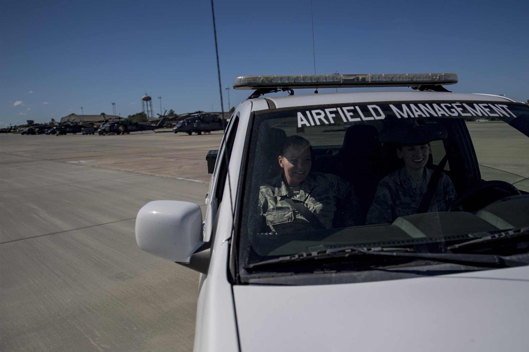Tech. Sgt. Shannon Walsh, left, 23d Operations Support Squadron NCO in charge of airfield management operations and Senior Airman Kelsey Seroogy, right, 23d OSS airfield management shift leader, drive past multiple HH-60G Pave Hawks, Oct. 19, 2016 at Moody Air Force Base, Ga. The 23d OSS’s airfield management section is responsible for the upkeep of runways and other airfield components. (U.S. Air Force photo by Airman 1st Class Daniel Snider)