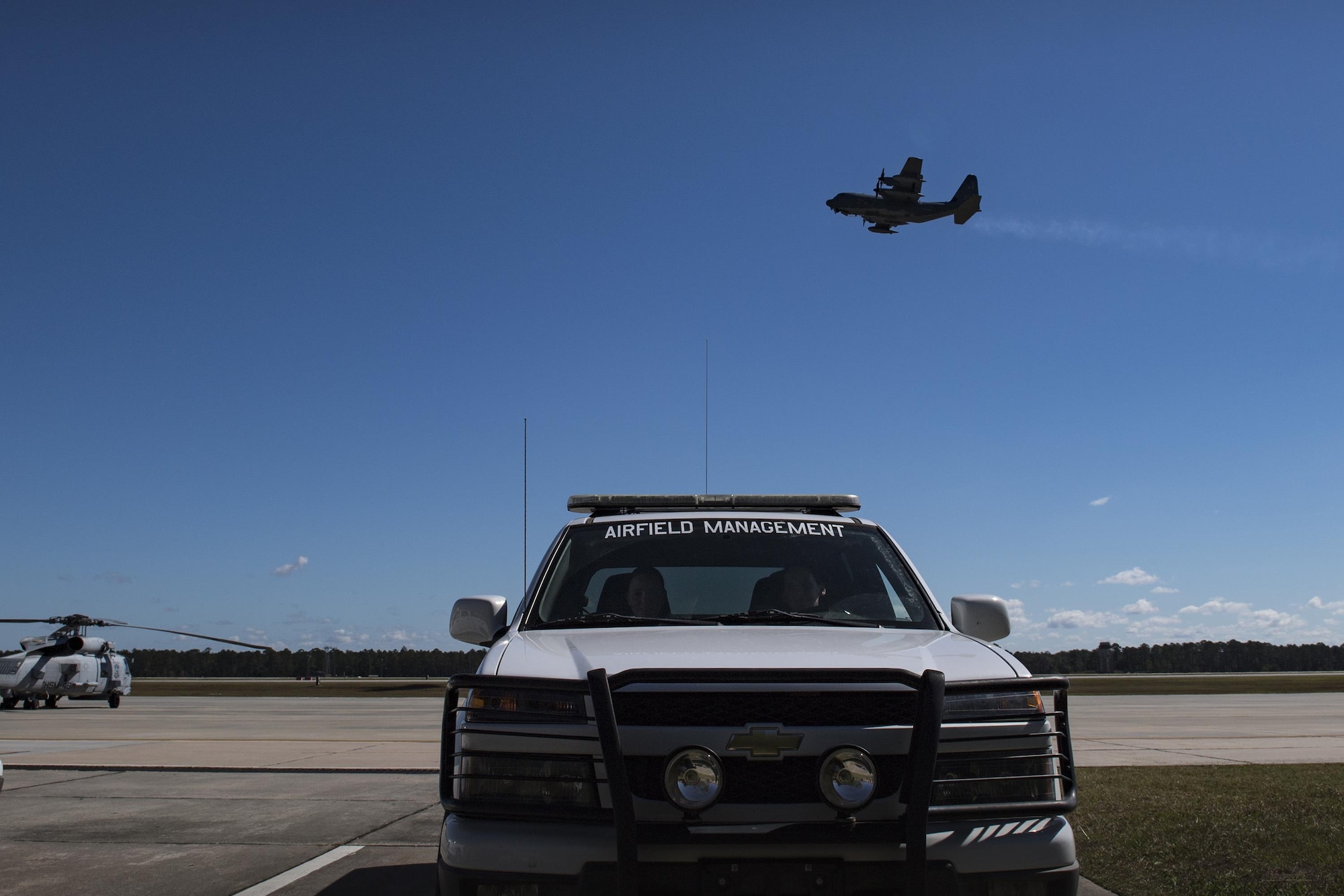 Tech. Sgt. Shannon Walsh, left, 23d Operations Support Squadron NCO in charge of airfield management operations and Senior Airman Kelsey Seroogy, 23d OSS airfield management shift leader, park their truck after a routine driven inspection while an HC-130J Combat King II ascends in the background, Oct. 19, 2016, at Moody Air Force Base, Ga. It’s safe to say anytime an aircraft is seen in Moody’s skies, members of airfield management are manning their stations. (U.S. Air Force photo by Airman 1st Class Daniel Snider)