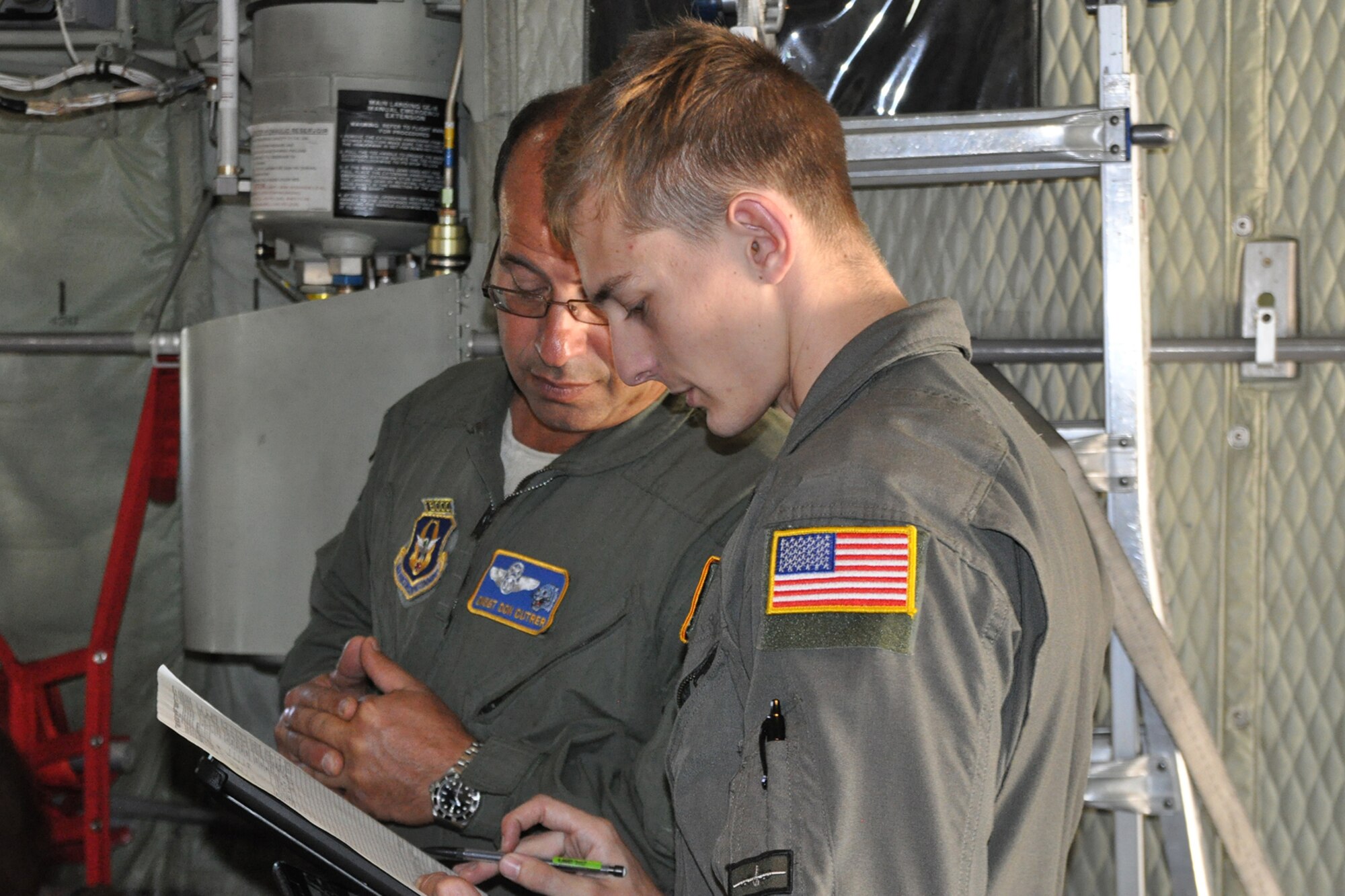 Chief Master Sgt. Donald Cutrer and Senior Airman Nicholas Orcutt, both loadmasters assigned to the 757th Airlift Squadron, review a load plan on the cargo deck of a C-130H Hercules tactical cargo aircraft while it sits on the flightline here prior to takeoff during the 910th Airlift Wing’s Civic Leader Flight for Educators, Oct. 19, 2016. The purpose of the event was to allow attendees to learn more about Air Force Reserve career opportunities from their local recruiting team and have a fuller understanding of the 910th’s mission and a greater appreciation for Air Force Reserve opportunities available to students in Northeast Ohio. (U.S. Air Force photo/Master Sgt. Bob Barko Jr.)