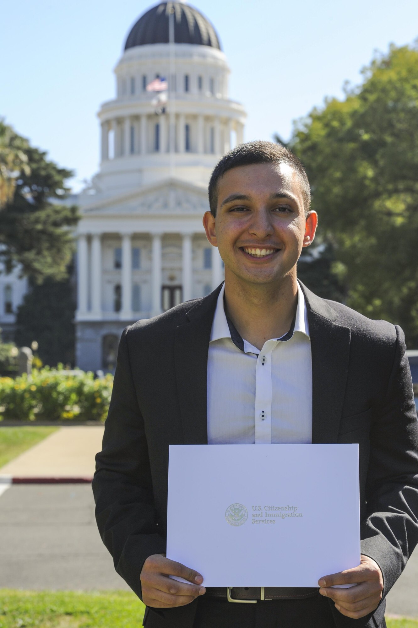 Airman Aris D. Soltani, a 940th Aircraft Maintenance Squadron personnelist, poses for a photo with U.S. citizenship certificate Oct. 11, 2016, in Sacramento, California. Soltani passed his citizenship test and recited the Oath of Allegiance earlier that day. (U.S. Air Force Photo by Senior Airman Tara R. Abrahams)