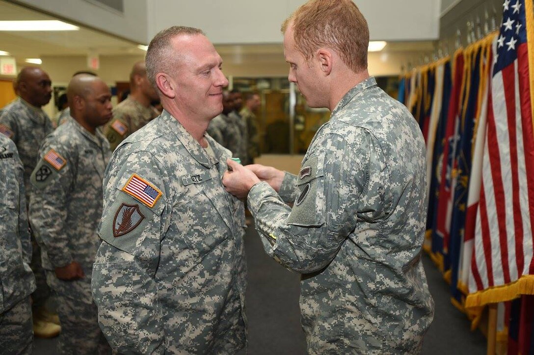 Sgt. David Lietz, left, public affairs specialist assigned to the 85th Support Command headquarters, receives an Army Commendation Medal during the command's battle assembly closing formation. Moments earlier Lietz received a promotion to sergeant reassigning him to the 318th Press Camp Headquarters.
(Photo by 2nd Lt. Jane Fox)