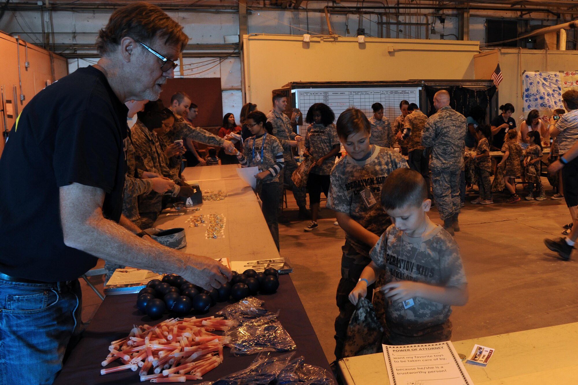 James Yang Hellewell, 56th Medical Operation Squadron family advocacy outreach manager, hands out stress balls Oct. 15 at Luke Air Force Base, Ariz. Hellewell was part of a mock deployment line during Operation Kids. (U.S. Air Force Photos by Airman 1st Class Pedro Mota)
