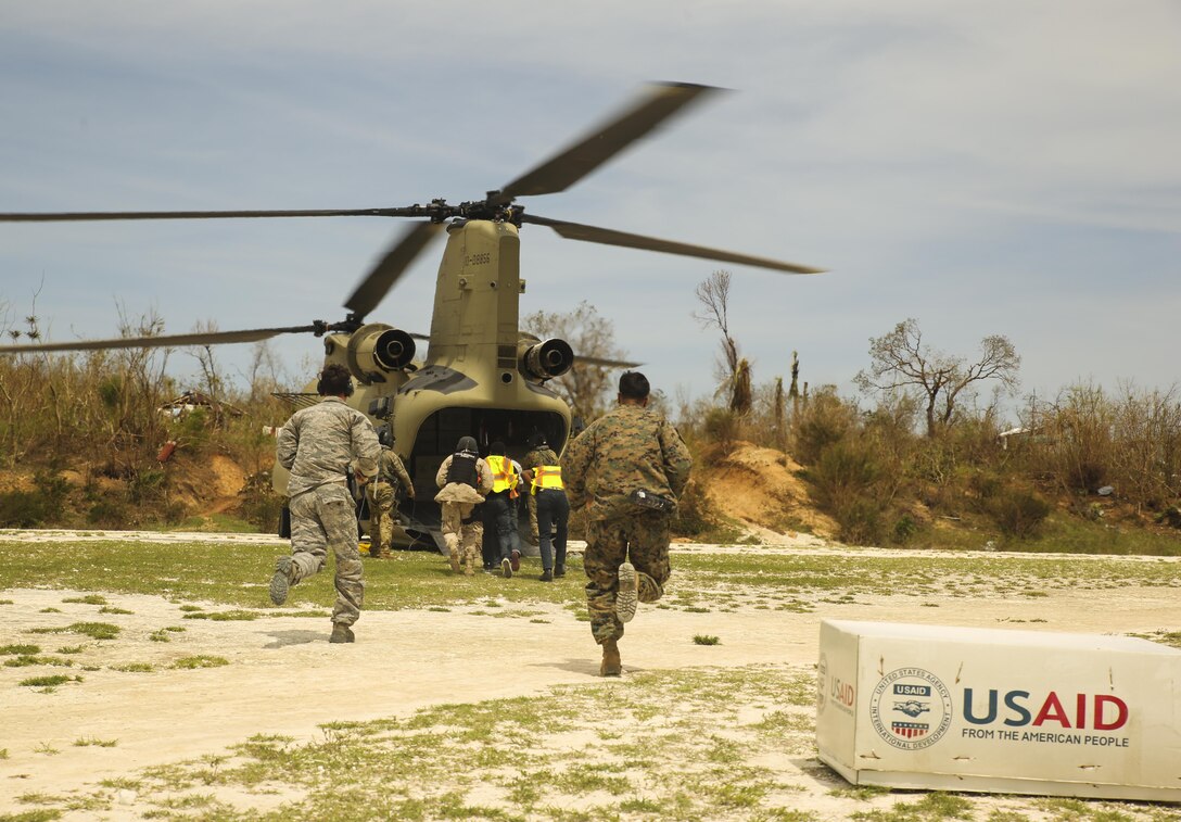 U.S. service members with Joint Task Force Matthew run toward a CH-47 Chinook helicopter from Joint Task Force-Bravo's 1st Battalion, 228th Aviation Regiment, to deliver supplies to the local police force at Jeremie, Haiti, Oct. 9, 2016. The Marines with Special Purpose Marine Air-Ground Task Force - Southern Command and soldiers with JTF-Bravo are part of Joint Task Force Matthew, a U.S. Southern Command-directed team deployed to Port-au-Prince at the request of the Government of Haiti, on a mission to provide humanitarian and disaster relief assistance in the aftermath of Hurricane Matthew. (U.S. Marine Corps photo by Cpl. Samuel Guerra))