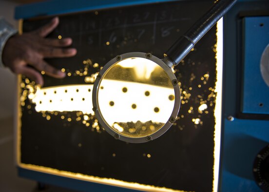 A magnifying glass enlarges a section of x-ray film at Minot Air Force Base, N.D., Oct. 17, 2016. Non-destructive inspection Airmen from the 5th Maintenance Squadron utilize x-rays for inspecting welds on the B-52H Stratofortress. (U.S. Air Force photo/Airman 1st Class J.T. Armstrong)