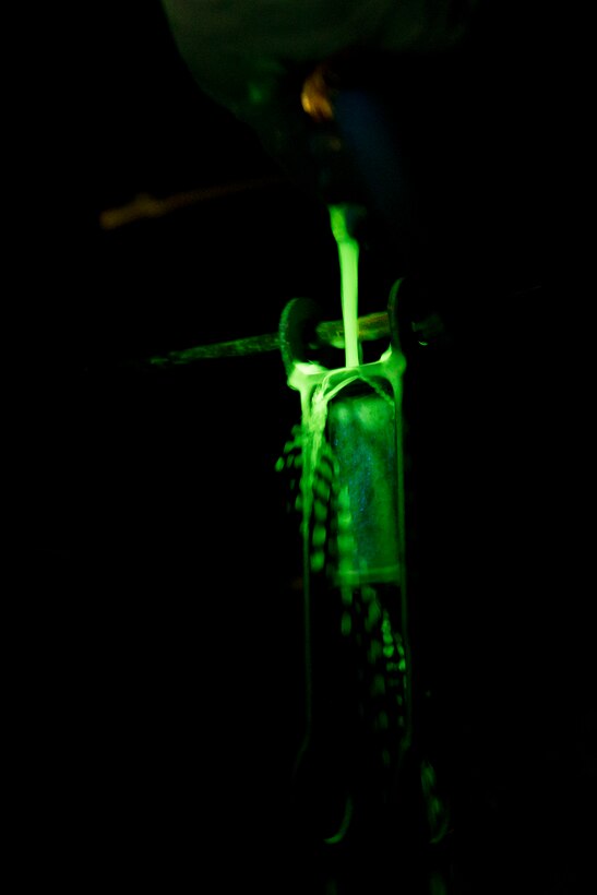A magnetic particle bath fluoresces under ultraviolet light during a magnetic particle inspection at Minot Air Force Base, N.D., Oct. 18, 2016. The fluorescing particles under ultraviolet light allow Airmen to easily locate cracks and imperfections on magnetized aircraft parts. (U.S. Air Force photo/Airman 1st Class J.T. Armstrong)