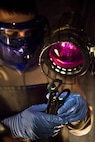 Airman 1st Class Landen Johnston, 5th Maintenance Squadron non-destructive inspection apprentice, performs a magnetic particle inspection under an ultraviolet light at Minot Air Force Base, N.D., Oct. 18, 2016. The fluorescing particles under ultraviolet light allow Airmen to easily locate cracks and imperfections on magnetized aircraft parts. (U.S. Air Force photo/Airman 1st Class J.T. Armstrong)