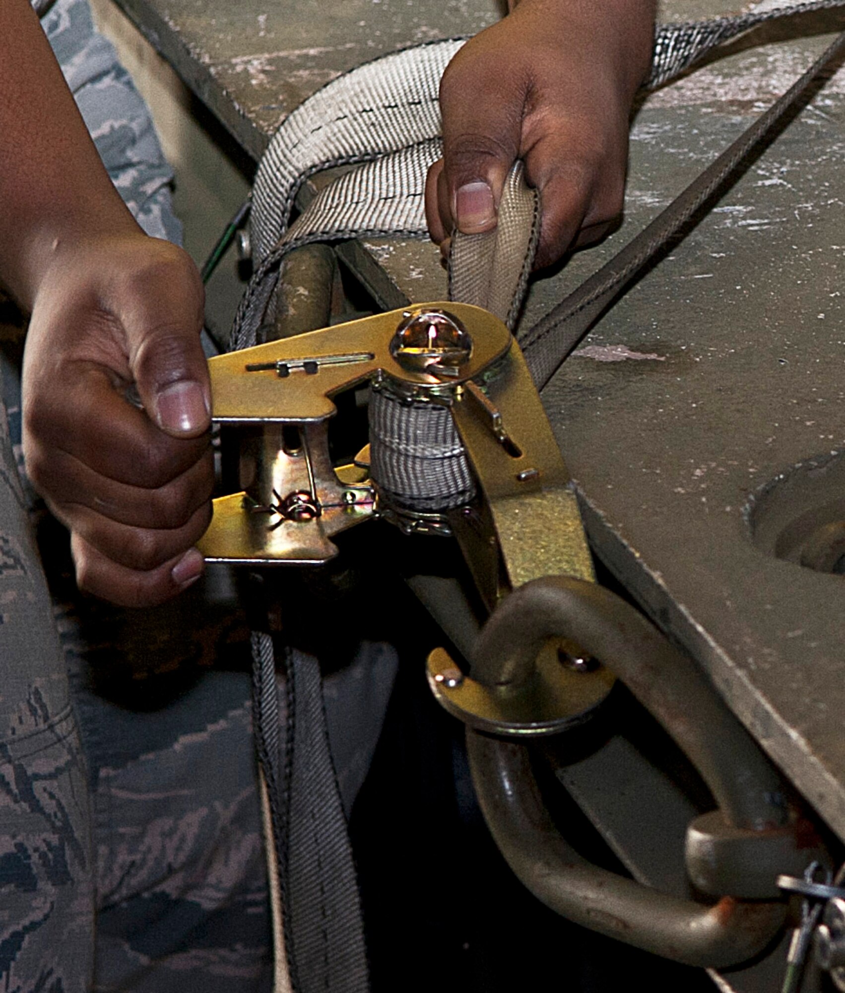 An Airman with the 5th Aircraft Maintenance Squadron tightens a strap for an inert munition during a bomb load competition at Minot Air Force Base, N.D., Oct. 14, 2016. The 5 AMXS hosted a quarterly load competition to showcase their attention to detail, teamwork, precision and bomb loading proficiency. (U.S. Air Force photo/Airman 1st Class Jonathan McElderry)