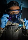 Airman 1st Class Alexander Shaikh, 5th Maintenance Squadron non-destructive inspection journeyman, shines a black light during a fluorescent penetrant inspection at Minot Air Force Base, N.D., Oct. 18, 2016. The black light aids Shaikh in locating cracks and imperfections on parts of the B-52H Stratofortress and aircraft support equipment. (U.S. Air Force photo/Airman 1st Class J.T. Armstrong)