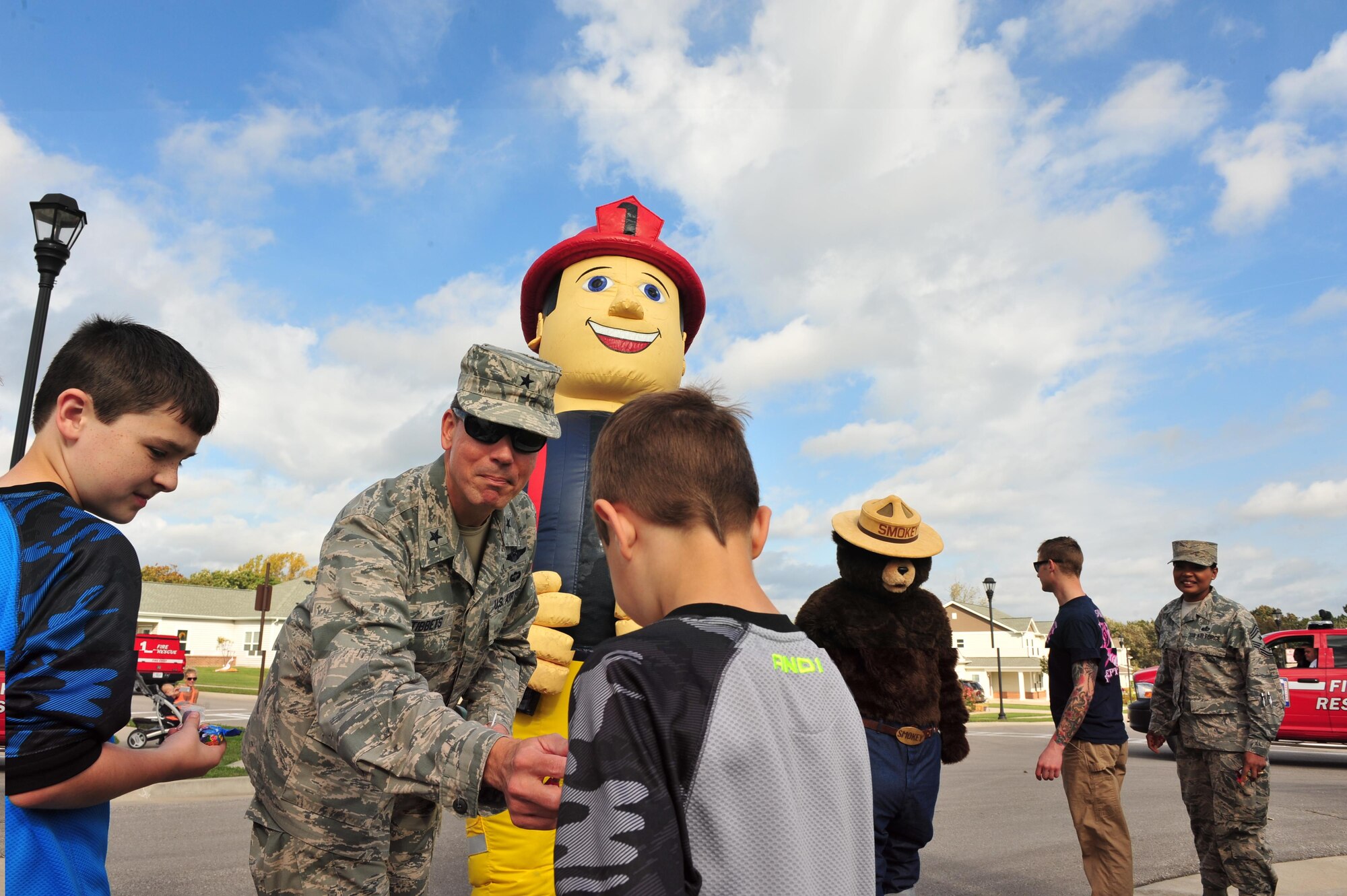 Brig. Gen. Paul W.Tibbets IV passes out candy to members of Team Whiteman during a Fire Prevention Week parade at Whiteman Air Force Base, Mo., Oct. 15, 2016. The parade passed through base housing and concluded at the base commissary. (U.S. Air Force photo by Senior Airman Jovan Banks)
