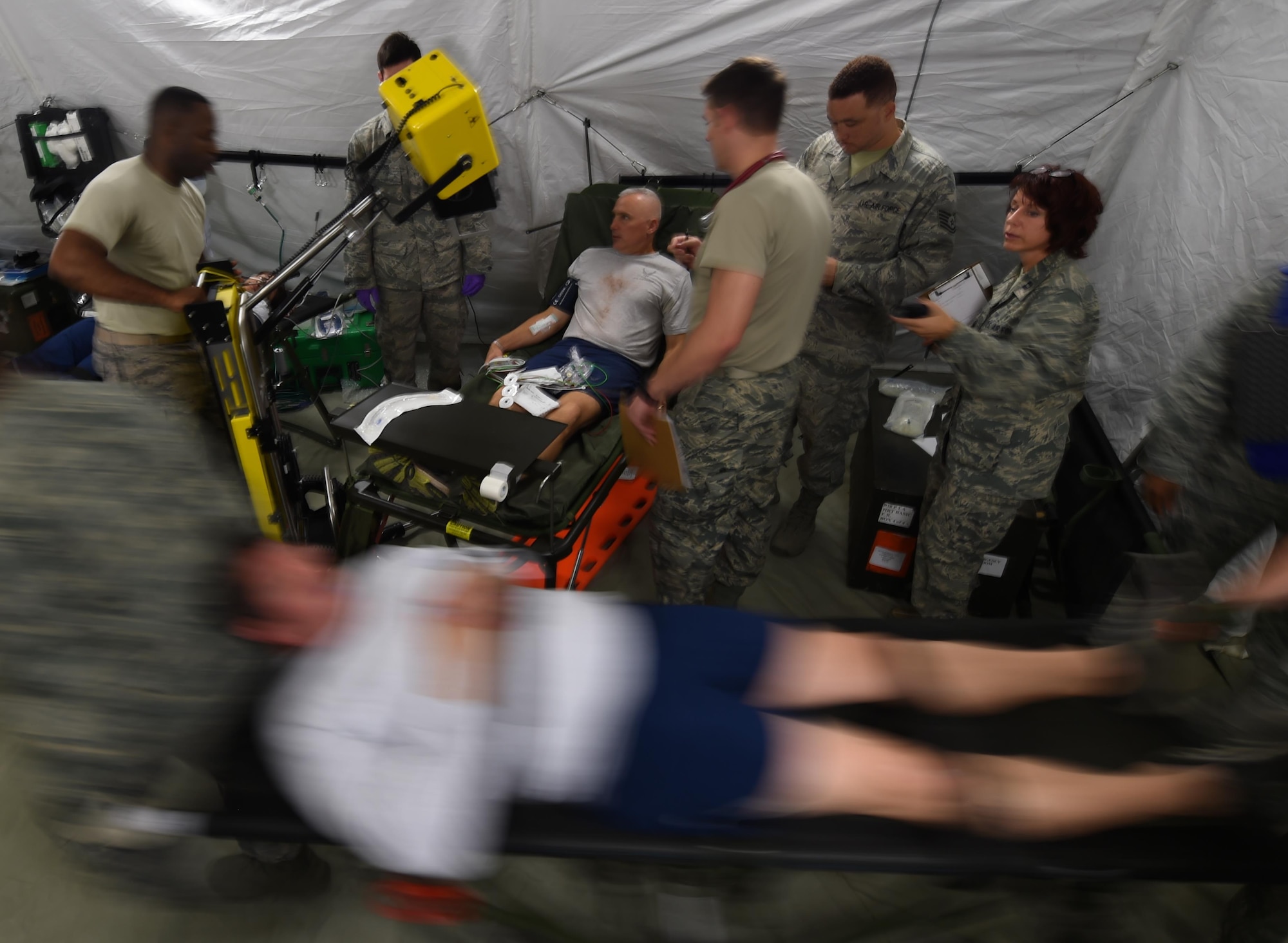 U.S. Air Force Emergency room doctors and technicians treat patients with simulated injuries and illnesses during a medical global response force training exercise at Joint Base Langley-Eustis, Va., Oct. 20, 2016. Members of the medical group put the 25-bed field hospital to the test while treating real-world and simulated patients. (U.S. Air Force photo by Staff Sgt. Natasha Stannard)