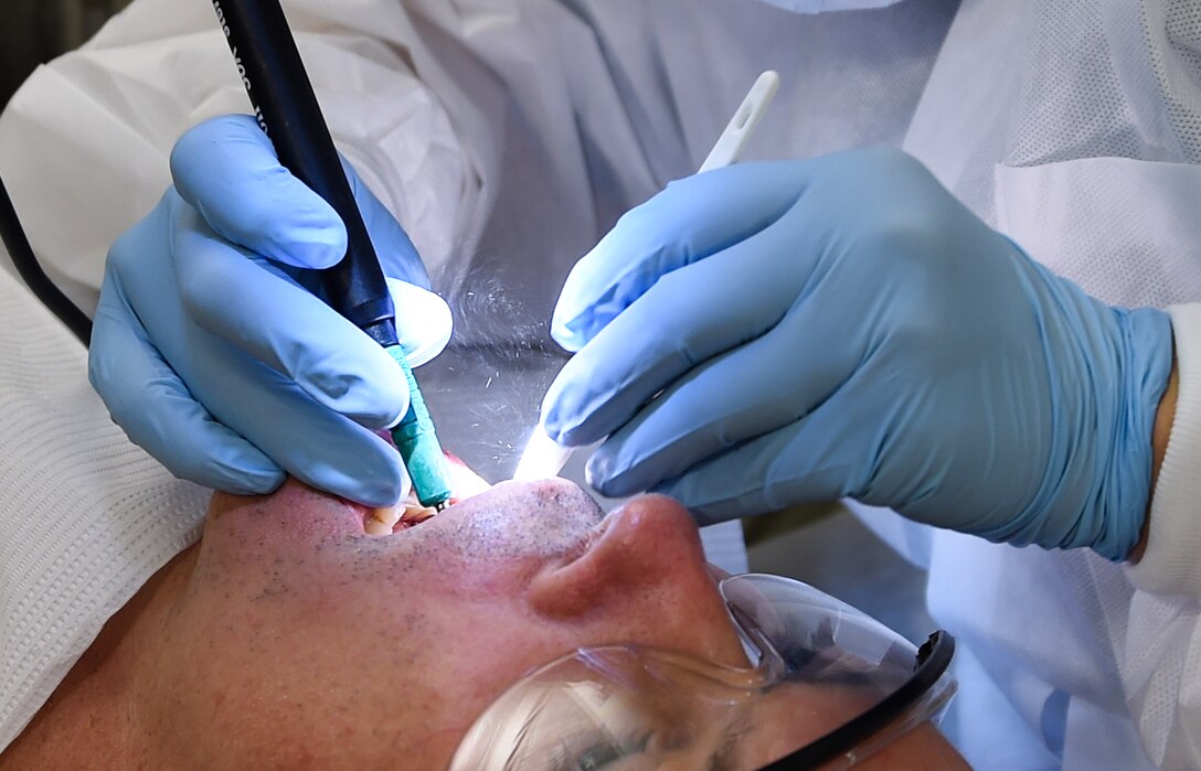 U.S. Air Force Tech. Sgt. Amanda Leak, 633rd Dental Squadron dental technician, cleans Col. Norman Fox’s, Expeditionary Medical Support commander, teeth during a routine dental check-up at a 25-bed field hospital on Joint Base Langley-Eustis, Va., Oct. 19, 2016. Active duty patients with routine medical appointments went to the field hospital as part of a medical global response force training exercise. (U.S. Air Force photo by Staff Sgt. Natasha Stannard)