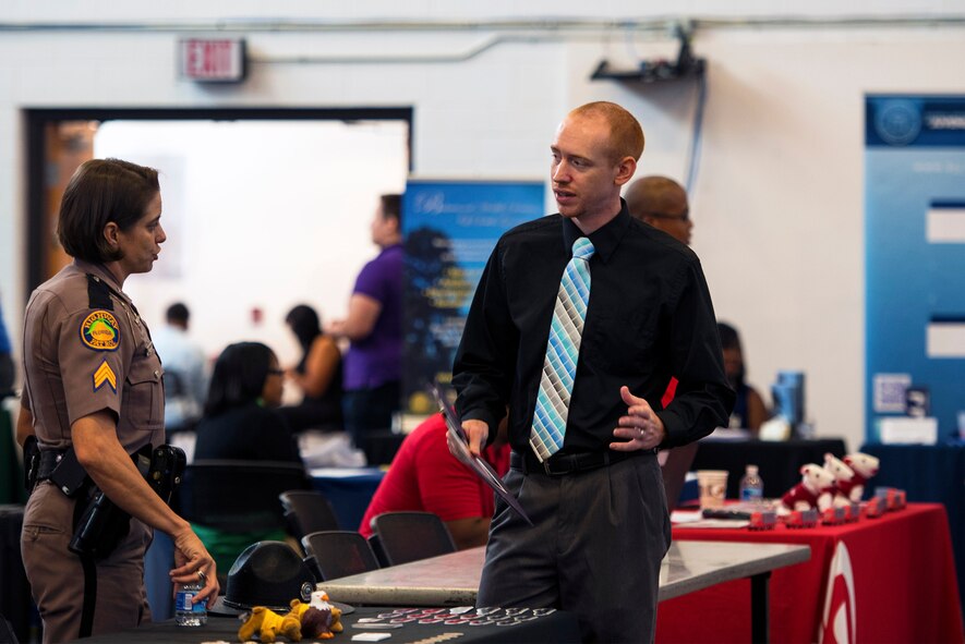 Senior Airman Joshua Markowski, 23d Equipment Maintenance Squadron aircraft metals technician, talks to Sergeant Mellow Scheetz, Florida highway patrolman, during a job fair, Oct. 20, 2016, at Moody Air Force Base, Ga. Although Markowski wants to continue pursuing work in the welding and machinery career field, he says it was good to have a variety of career options to learn about as he prepares to separate from the Air Force this year. (U.S. Air Force photo by Airman 1st Class Greg Nash)