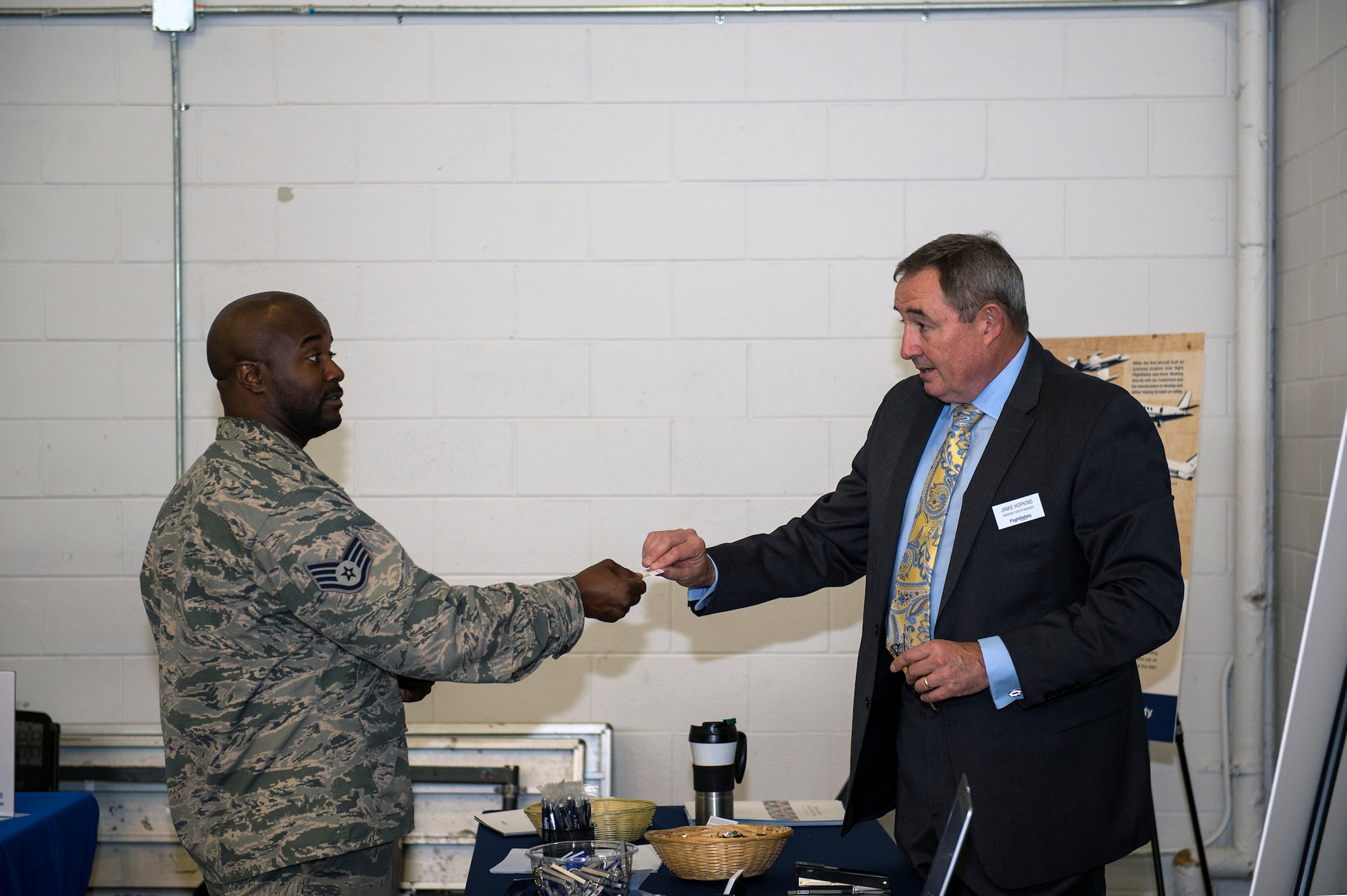 Staff Sgt. Chad Bailey, left, 723d Aircraft Maintenance Squadron combat-oriented supply operator, accepts a business card from Jamie Hopkins, an assistant center manager for a local aviation company, during a job fair, Oct. 20, 2016, at Moody Air Force Base, Ga. The fair was designed for job seekers to establish relationships with employers as they presented their resumes in hopes of getting hired on the spot or being considered for additional interviews. (U.S. Air Force photo by Airman 1st Class Greg Nash)