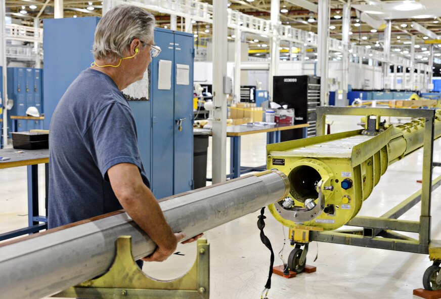 Joe Harder, with the 551st Commodities Maintenance Squadron, shows the ease of fitting a KC-135 boom into its boom housing using a rollable hoist without having to physically lift and fit it himself. (Air Force photo by Kelly White)