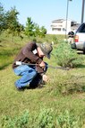 John Lee, foreground, with the 548th Propulsion Maintenance Squadron, is working with Tinker’s Environmental Office to track fire ants on base. Tom Miller, background, a geographic information systems analyst with Colorado State University, uses GPS to map the fire ants’ mounds around the parking lot of the Child Development Center South. The ants were most likely brought onto base in plant materials and have carved their trail systems thoroughly around the lot. (Air Force photo by Kelly White)