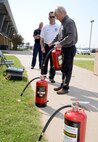 Bill Green and Todd Evers showed Dan Henry, with AAFES, how to properly use a fire extinguisher. Employees of the Base Exchange are required to have commercial cooking and fire extinguisher training twice a year. (Air Force photo by Kelly White)