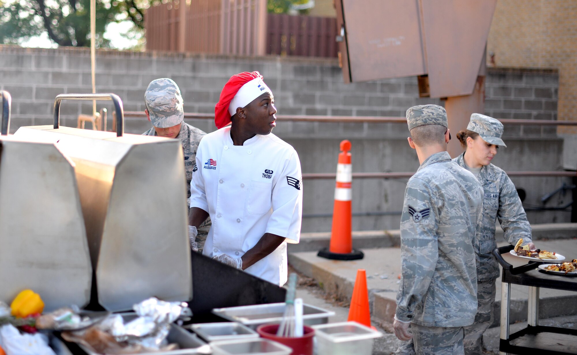 U.S. Air Force Senior Airman Kaden Thomas, 55th Force Support Squadron food service specialist, look over his shoulder to check his time as his team competed in the Iron Chef Grill Masters competition at the Ronald L. King Dining Facility Oct 13, Offutt Air Force Base, Neb.  Food service professionals were give three meat items, four vegetables, three fruits and a basket containing three secret ingredients to make dishes to present to a panel of judges.  (U.S. Air Force photo by Josh Plueger)