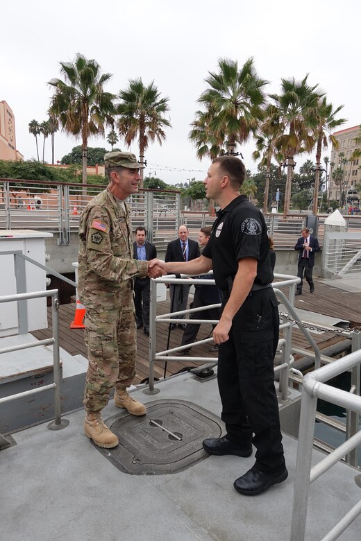Oct. 14, Los Angeles Port Police Officer, Michael Glimpse, greets South Pacific Division Commander Col. Peter Helmlinger, as he boards the police dive boat for his tour of the Port of Los Angeles.