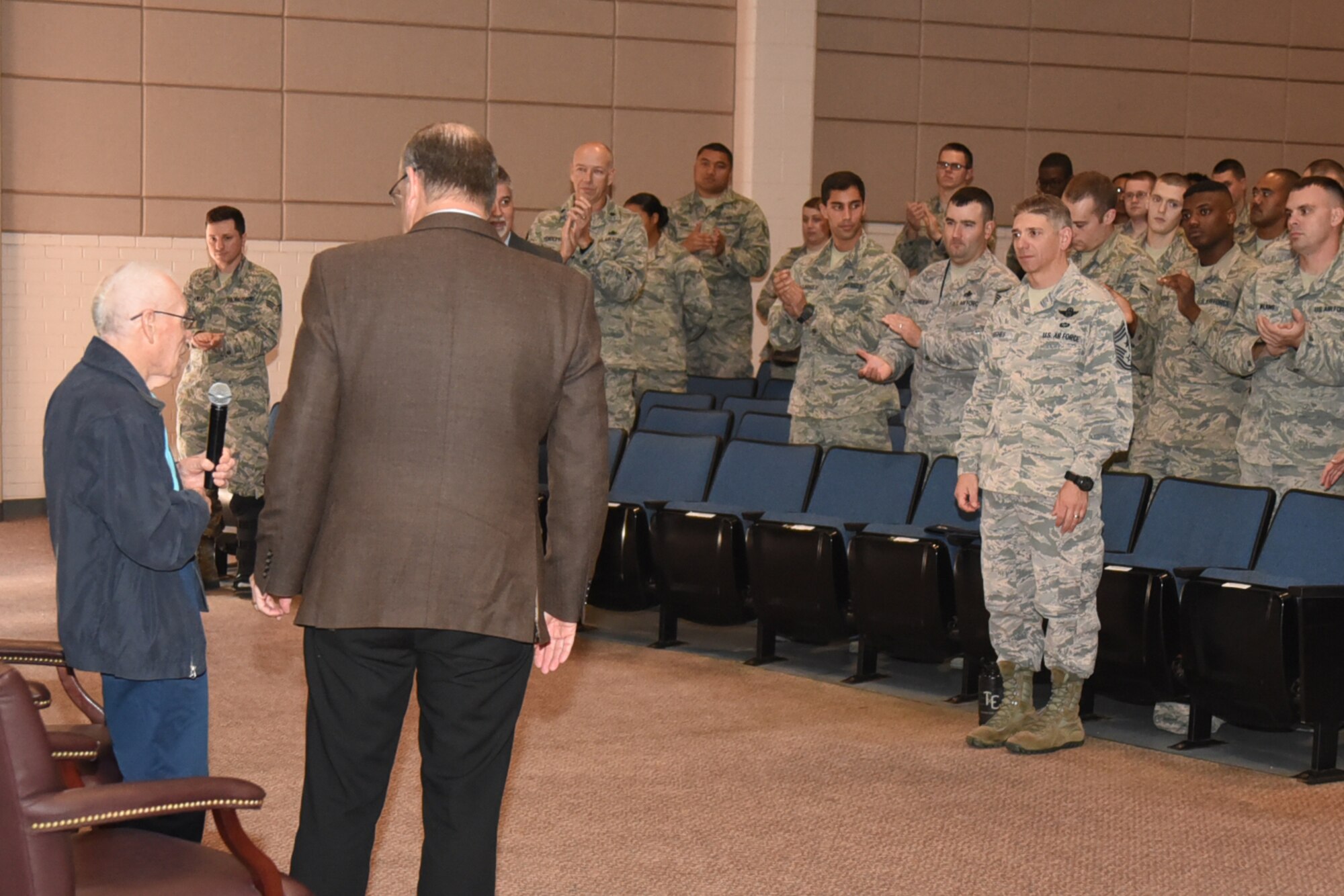 Airmen give Eddie Graham, retired Army sergeant, a standing ovation after his speech Oct. 20, 2016. Graham gave a speech about his experiences during World War II and surviving the Bataan Death March. (U.S. Air Force photo/Senior Airman Christopher Thornbury)