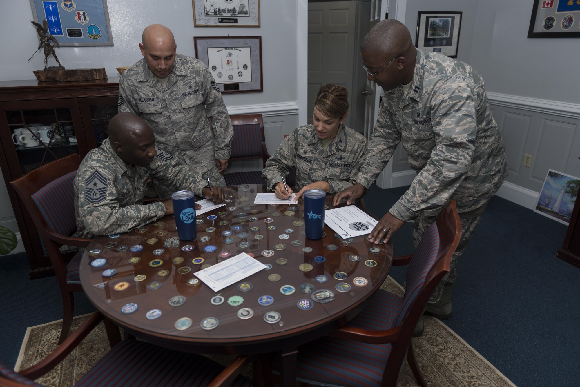 Col. Michele Edmondson, 81st Training Wing commander, and Chief Master Sgt. Vegas Clark, 81st Training Wing command chief, sign their Combine Federal Campaign donation slip at the 81st TRW Wing Headquarters Oct 20, 2016, on Keesler Air Force Base, Miss.  Edmondson and Clark lead the way by participating in the base’s goal of 100% face-to-face contact concerning the CFC.  The CFC campaign runs 24 Oct. – 2 Dec.  (Air Force Photo by Andre’ Askew/Released)   