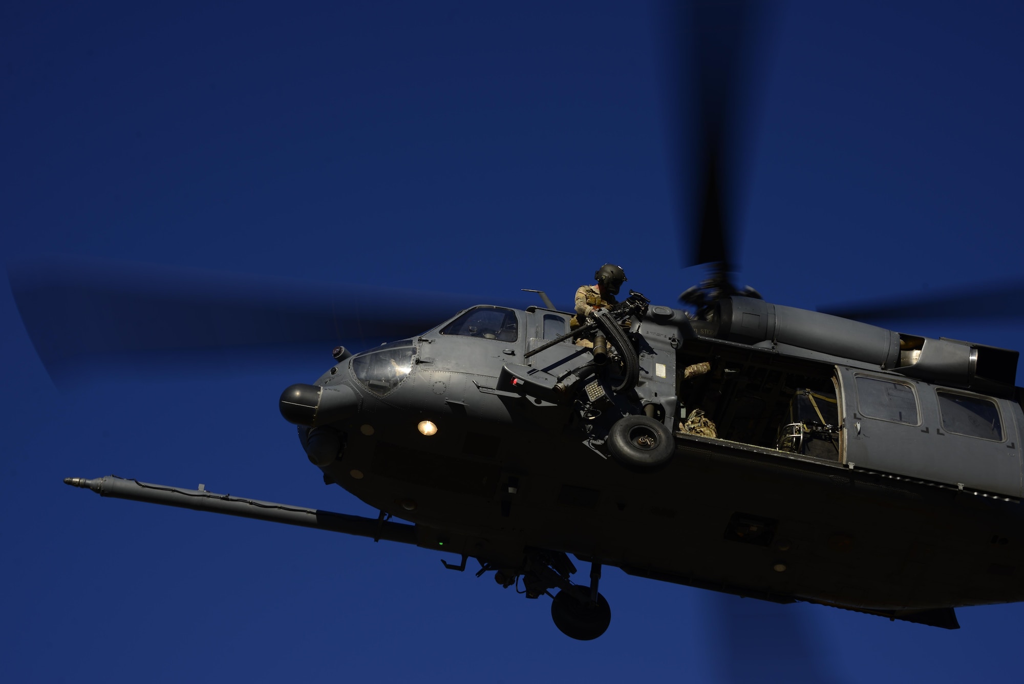 A special mission aviator assigned to the 55th Rescue Squadron surveys the area around the aircraft before descending at Davis-Monthan Air Force Base, Ariz., Oct. 18, 2016.  The 55th RQS assisted pararescuemen assigned to the 48th Rescue Squadron with alternate insertion/extraction training. (U.S. Air Force photo by Senior Airman Betty R. Chevalier)