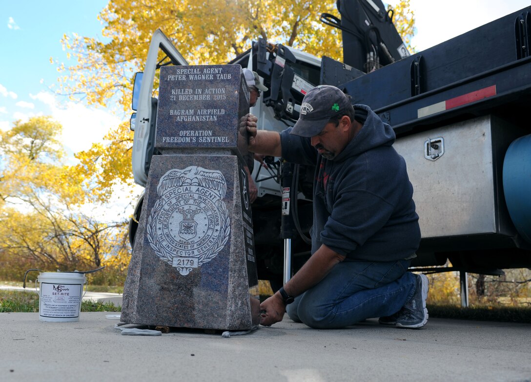 Mark Luken, an engraver with West River Monument Company in Rapid City, South Dakota, sets an engraved monument at Ellsworth Air Force Base, S.D., Oct. 18, 2016. The monument was dedicated to Special Agent Peter Taub, a member of the Air Force Office of Special Investigations Detachment 816, who died from wounds suffered during an attack by a suicide bomber on a motorcycle near Bagram Airfield, Afghanistan, Dec. 21, 2015. (U.S. Air Force photo by Airman 1st Class Denise M. Jenson)